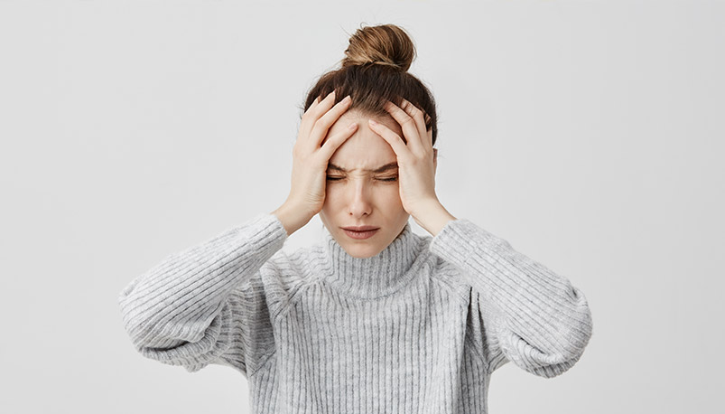 kobieta trzymająca się za głowę - migrena z głowy